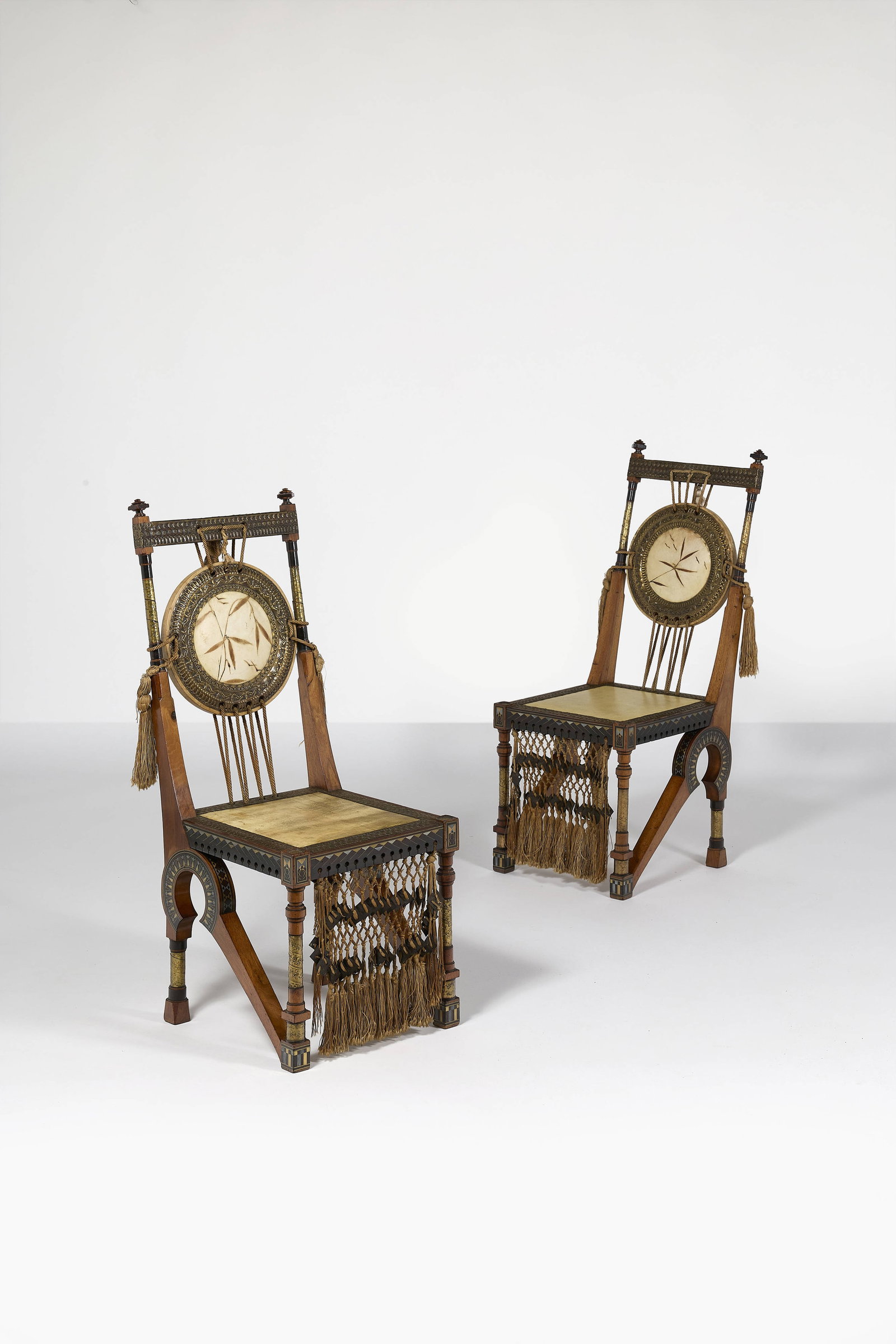 Carlo BUGATTI: Carlo BUGATTI Paire de chaises – circa 1902 Structure en noyer naturel et teinté, à décor d’incrustations de laiton et d’étain, de cuivre repoussé et