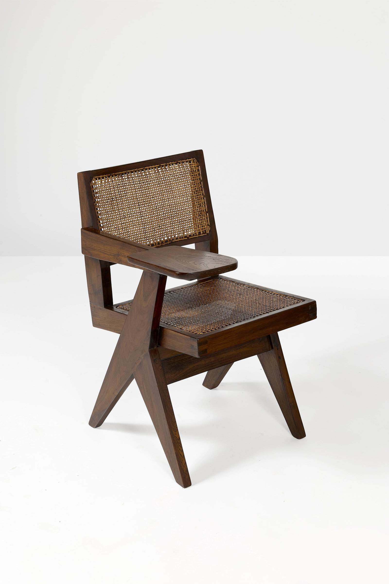 Pierre JEANNERET: Pierre JEANNERET Chaise « Classroom chair » – circa 1960 Teck et cannage 79 × 60 × 65 cm Provenance : Bâtiments administratifs, Chandigarh, Inde