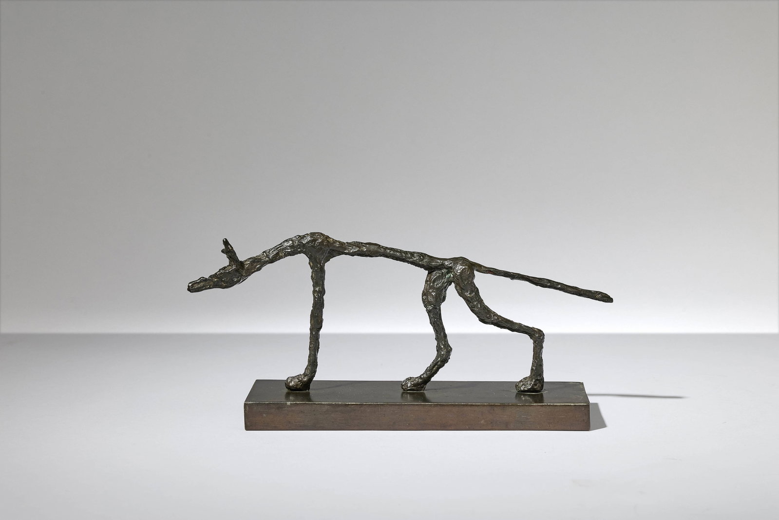 Diego GIACOMETTI: Diego GIACOMETTI «Loup » – circa 1970 Socle en métal et sculpture en bronze patiné Sculpture : 8,5 × 22,5 × 2,5 cm Socle : 1,5 × 18 × 7 cm Provenance :