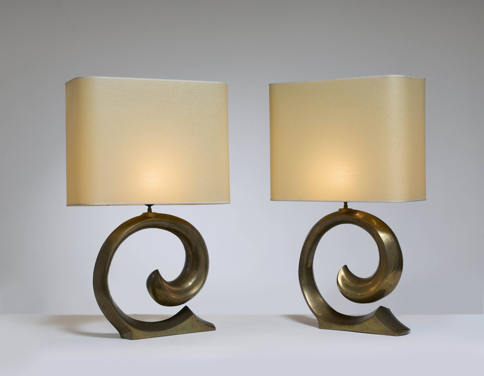 Pierre CARDIN (attribué à): Pierre CARDIN (attribué à) Paire de lampes – circa 1970 Piètement en laiton doré patiné formant un enroulement, abat-jours en tissu Avec abat-jour : 73,5 × 45,5 