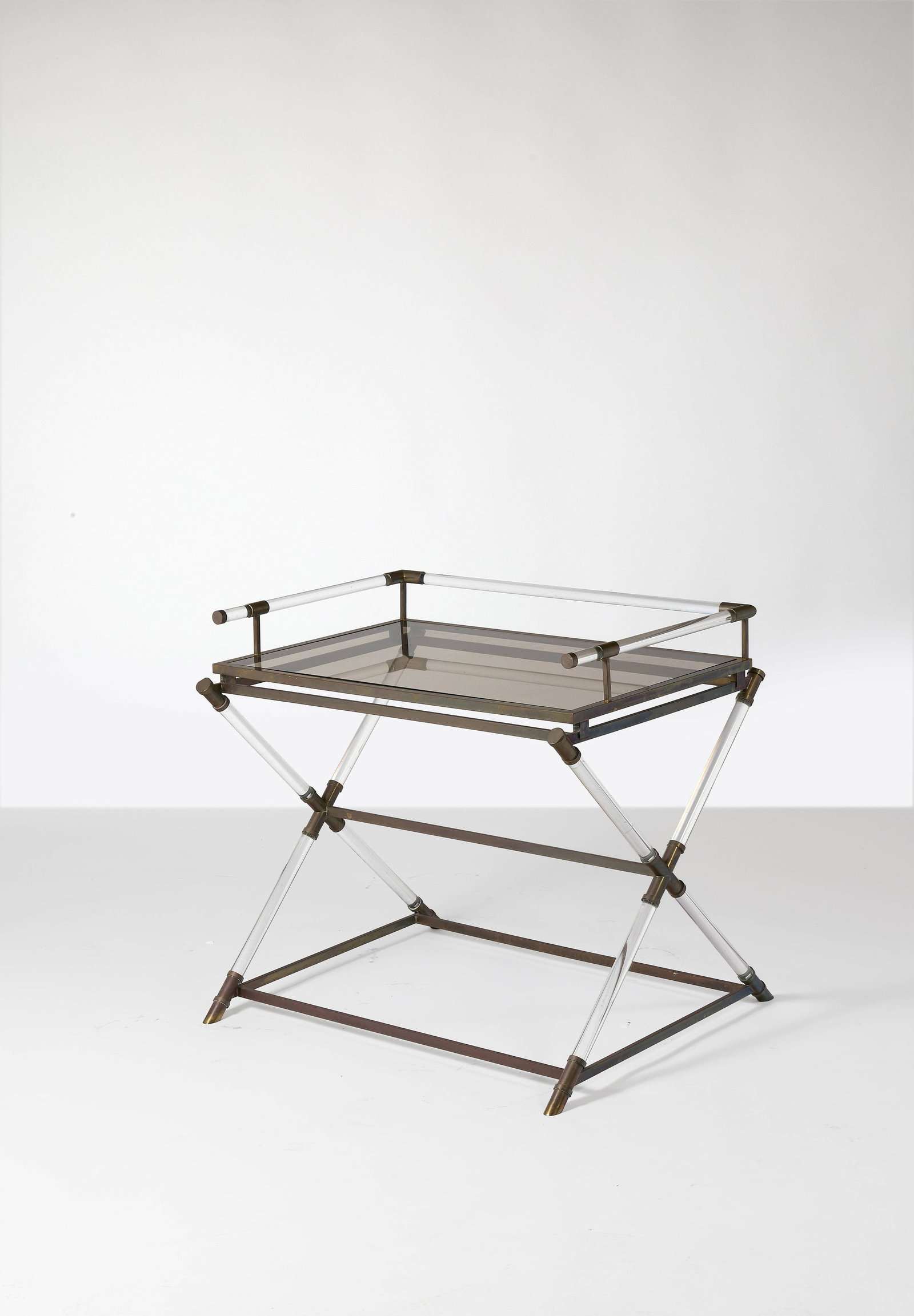 TRAVAIL FRANÇAIS: TRAVAIL FRANÇAIS Desserte – circa 1970 Structure en méthacrylate et laiton, plateau en verre fumé 83 × 90 × 68 cm A french methacrylate, brass and tinted glass desserte