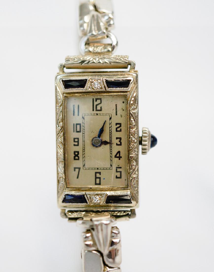 Art Deco Bruner 18K White Gold Watch: An art deco wrist watch stamped Bruner 18K inside. 18k white gold and appears to be constructed of diamonds and sapphires. Measures 1/2" x 7/8". Not running. We ship most items in house. Exclusions in
