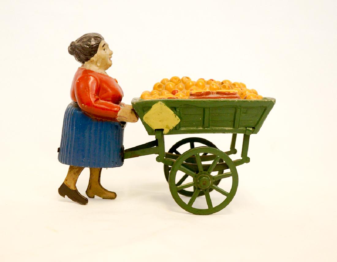 Martin Fernand Tin Figures Orange Vendor Toy: Martin Fernand tin-figures Orange Vendor wind up toy. Marked Brevete S.G.D.G. on foot. Measures 5.25" x 6" (13.5 cm x 15.5 cm). One chip on side of fruit cart. We ship most items in house. Exclusions 