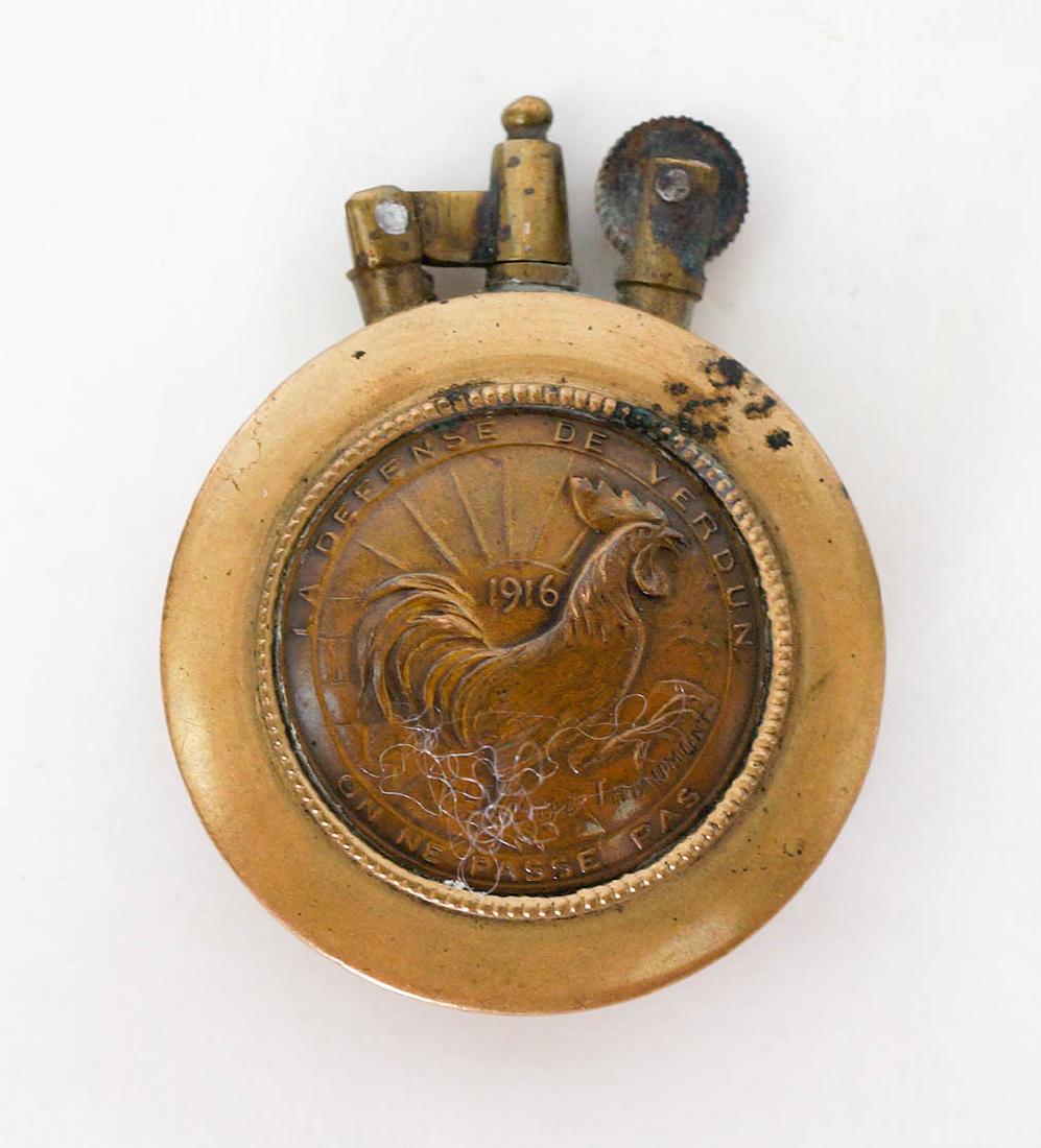 WW1 Trench Art Lighter: [Trench art, WWI, WW1, Lighter] Gallic Rooster Defense of Verdun trench art lighter. Measures 2.75" x 2". Estate of Earl E. Buchanan, Gunsmith, Kooskia, ID. We ship most items in-house with the except