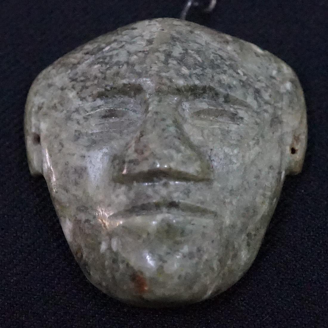 Antique Jade Pendent: Antique Jade Pendent. Unique primitive carved face in dark green jade with drilled hole and metal bail. Dimensions: 1 7/8 inch x 1 3/4 inch. Excellent condition. We ship most items in this auction in-