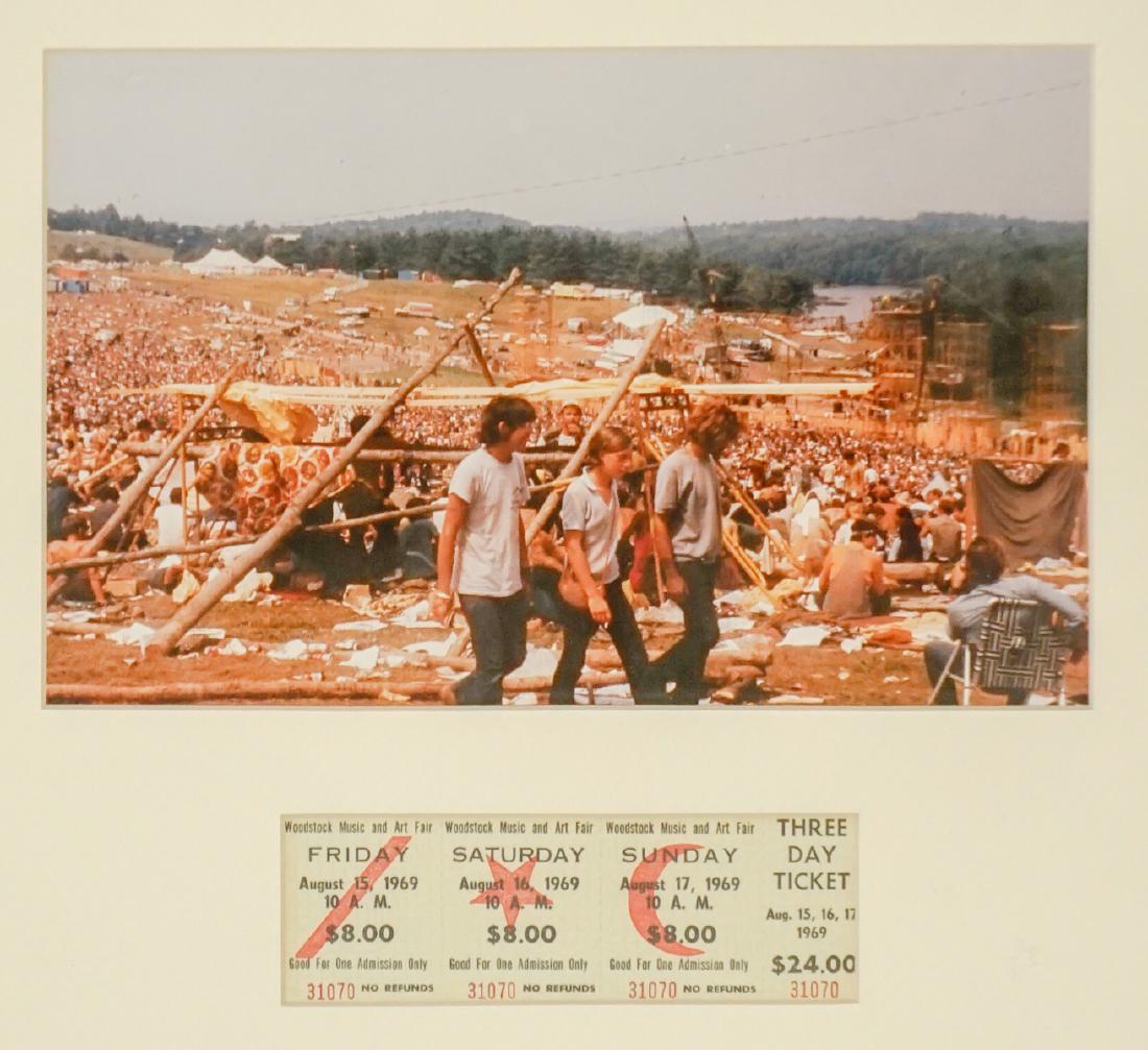 Frame Original Woodstock Ticket with Photograph: An authentic Woodstock ticket framed with a photo taken at the concert. Measures 15 in. x 16 in. total. Not examined out of frame. If lot is absent of a condition report a condition report may be requ