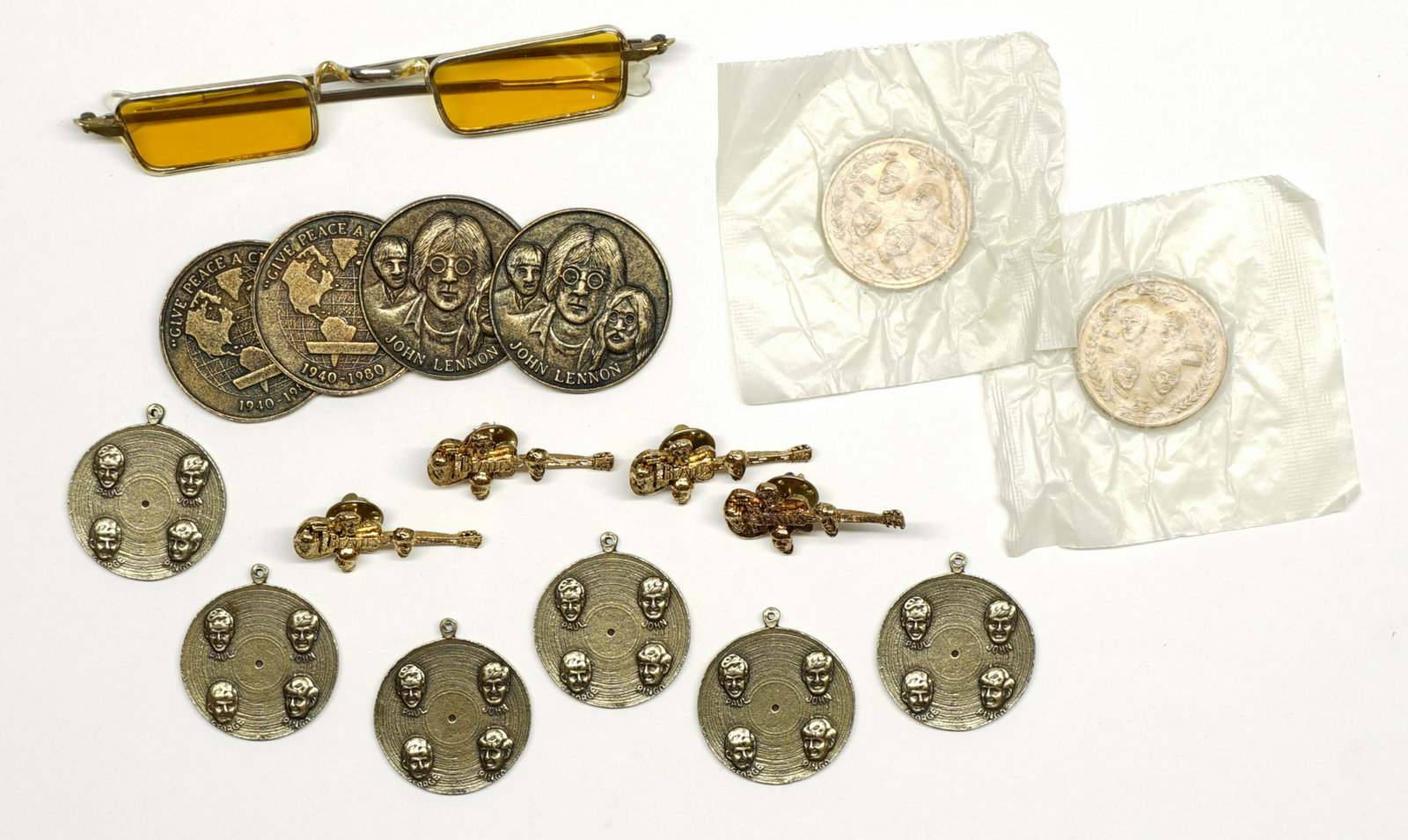 Beatles Tokens, Charms and Pins: The Beatles souvenir tokens, charms and pins. Tokens and charms measure 1.25 in and 1.5 in. Provenance: Private Collection Missoula, Montana. If lot is absent of a condition report a condition report 