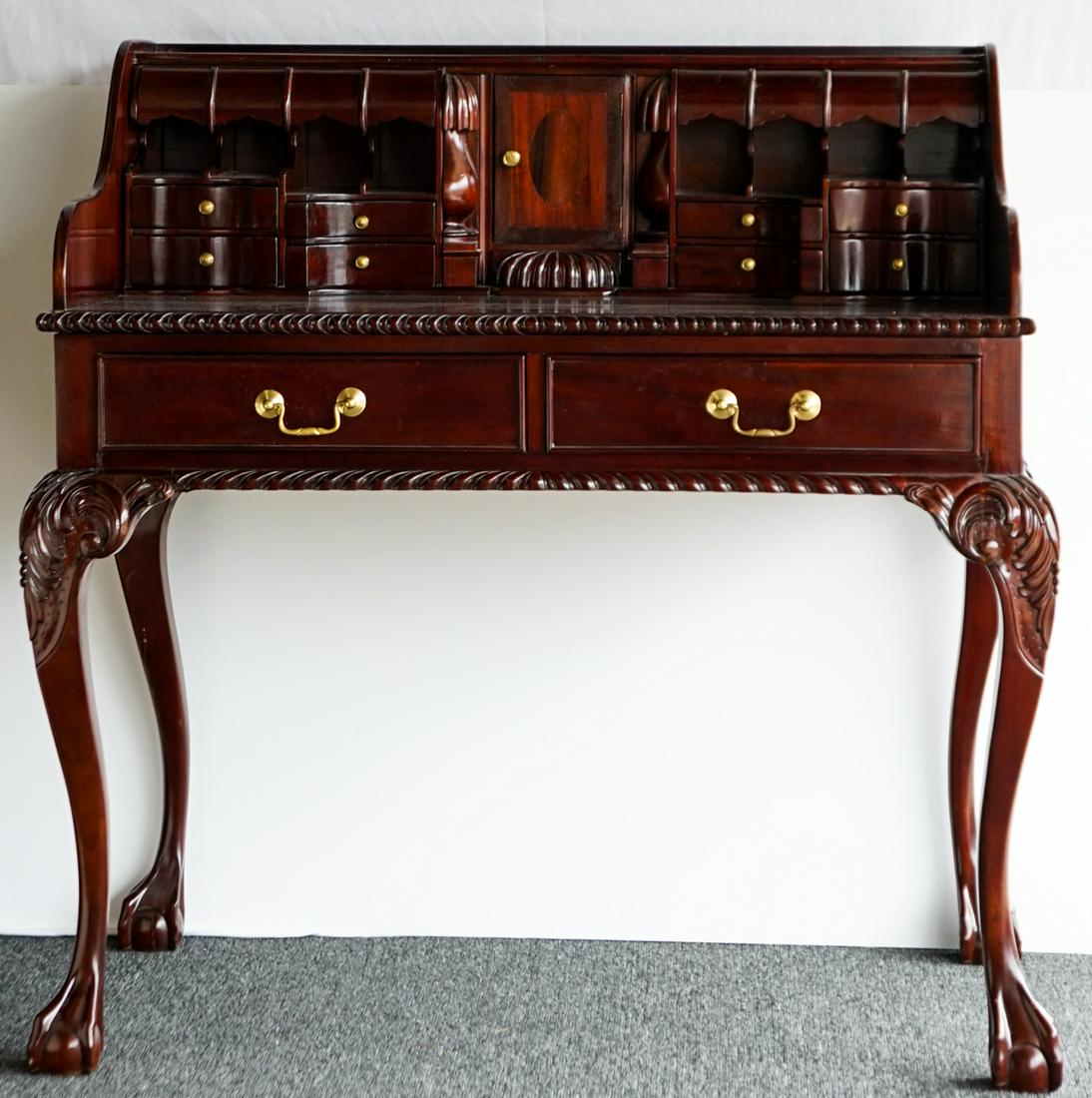 Indonesian Mahogany Secretary Desk: Two part Indonesian Mahogany Secretary Desk. Top section with central door, pigeon holes, 8 visible drawers, 3 hidden drawers and leather inset writing surface. Bottom section with 2 half drawers over