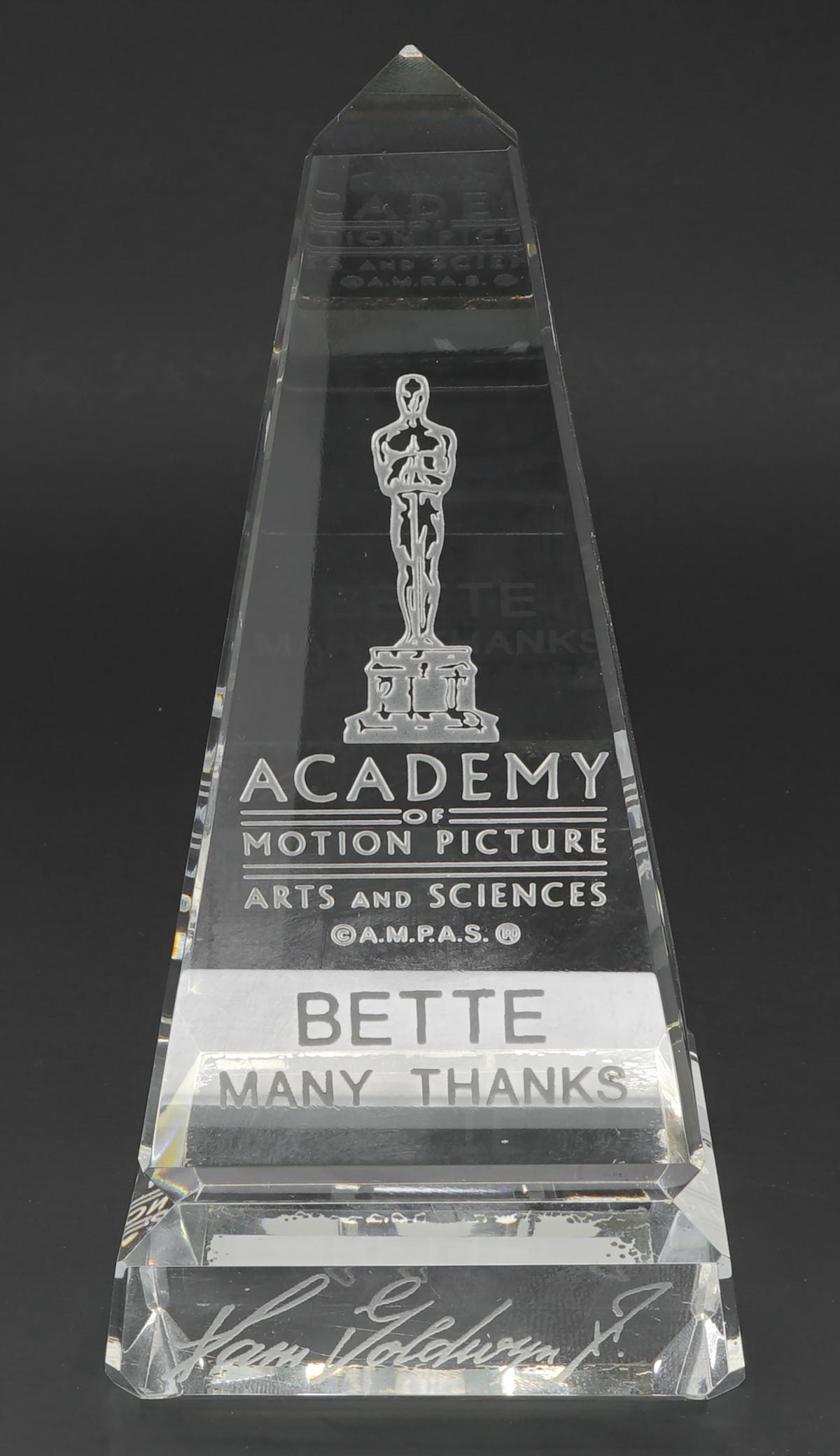 Bette Davis Crystal Award From ©A.M.P.A.S.®: Bette Davis crystal award from the ©A.M.P.A.S.® Etched 'Bette Many Thanks' and with Samuel Goldwyn's facsimile signature along base. Measures 5.25 in. x 2.625 in. Excellent condition with no damage 
