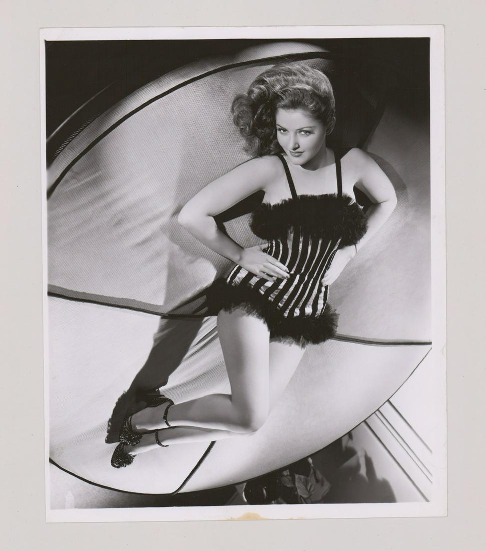 Martha Vickers Photographed by Bert Six: Martha Vickers photographed by Bert Six. Glossy surface, single-weight gelatin silver print. Measures 9.875 in. x 8 in. F-G/G with creases. Provenance: recent Mark Rucker collection, previously the Bj