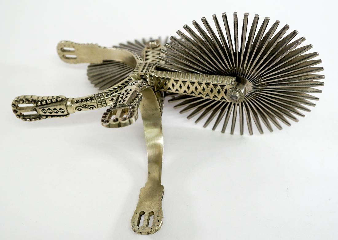 19th Century South American Large, Ornate Spurs: South America, Bolivia or Argentina, Spanish Colonial influenced, circa 19th century, Hand-forged steel spur wheel with dozens of small spikes, a short suspension pin capped with a pair of bulb-adorne