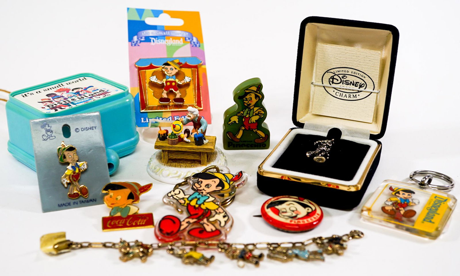 Disney and Pinocchio Memorabilia: Vintage Disney and Pinocchio. Includes: Pinocchio bakelite pencil sharpener; Pinocchio Olszewski Showcase; Sterling Charm; and more. Provenance: Private Collection Missoula, Montana. If lot is absent 