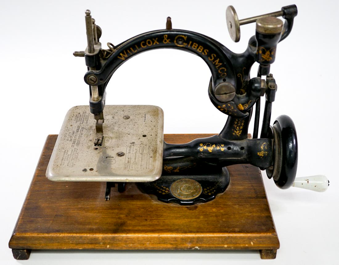 Wilcox and Gibbs Sewing Machine: Wilcox and Gibbs Sewing Machine. Measures 8.25 in. tall x 12 in. x 6 in. Base measures 11 in. x 8 in. x 1.5 in. Total height is 9.75 in. Serial number B588688. Provenance: Gatz Hjortsberg (American No