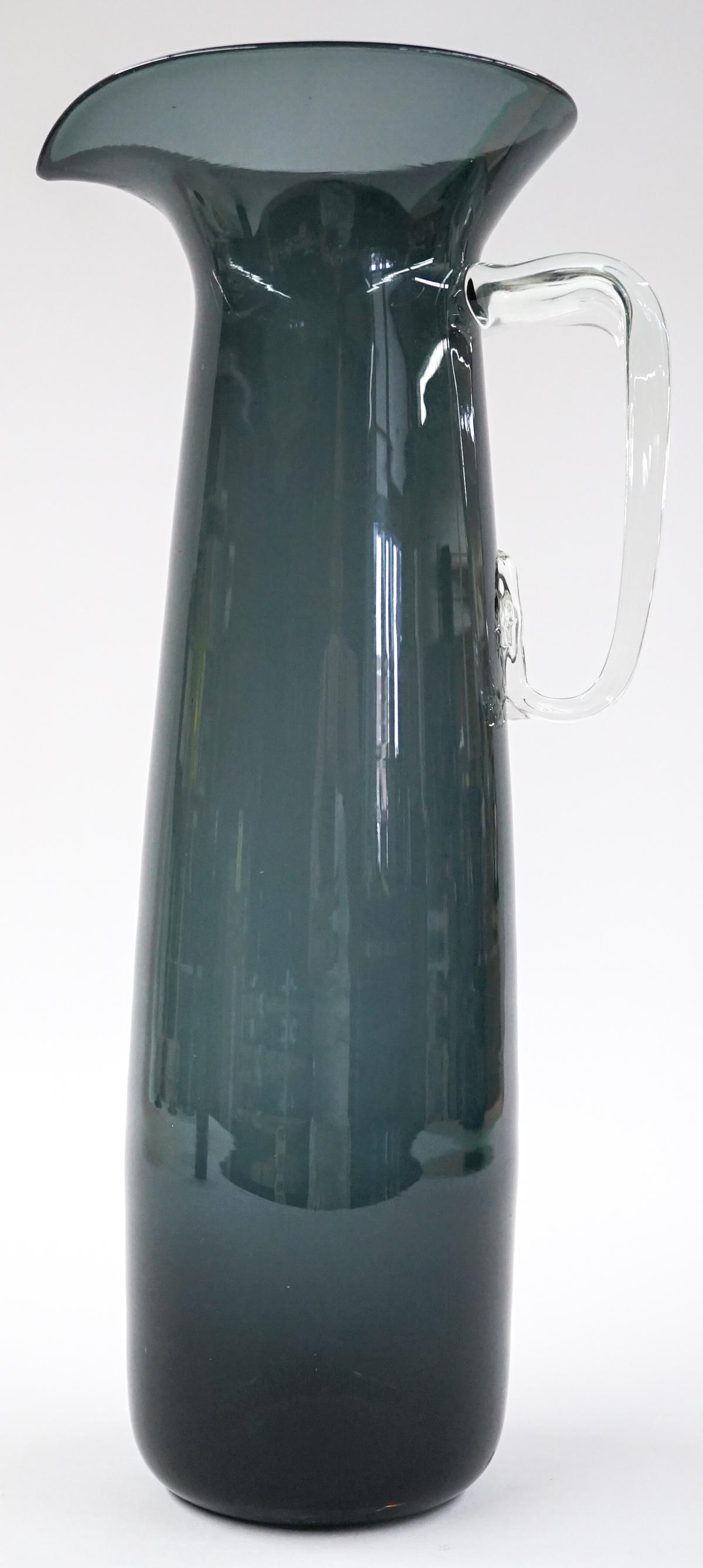 [Blenko] Mid-Century Charcoal Glass Pitcher: Blenko (or other maker) mid-century charcoal glass pitcher. Wayne Husted. #586. Measures at base 3.5 in. diameter with a total height of 13.5 in. No chips, cracks or repairs. Provenance: Tri-Cities, W