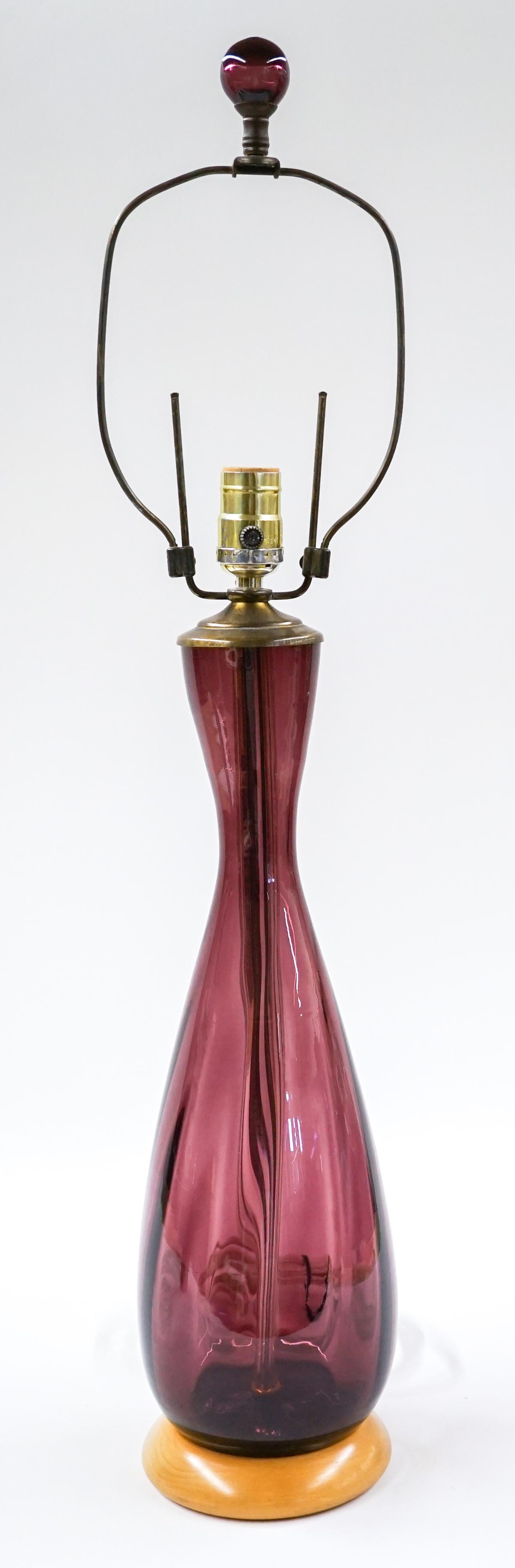 [Blenko] Mid-Century Amethyst Glass Lamp: Blenko (or other maker) mid-century amethyst glass lamp on wood base. Measures 30 in. tall and 5 in. diameter at base. No chips, cracks or repairs. These have not been tested. Provenance: Tri-Cities, 