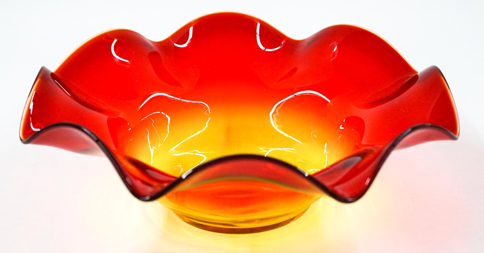 [Blenko] Mid-Century Ruffled Glass Bowl: Blenko (or other maker) mid-century tangerine ruffled glass bowl. Measures at base 3.75 in. diameter and 10 in. across with a total height of 3.75 in. No chips, cracks or repairs. Provenance: Tri-Citi