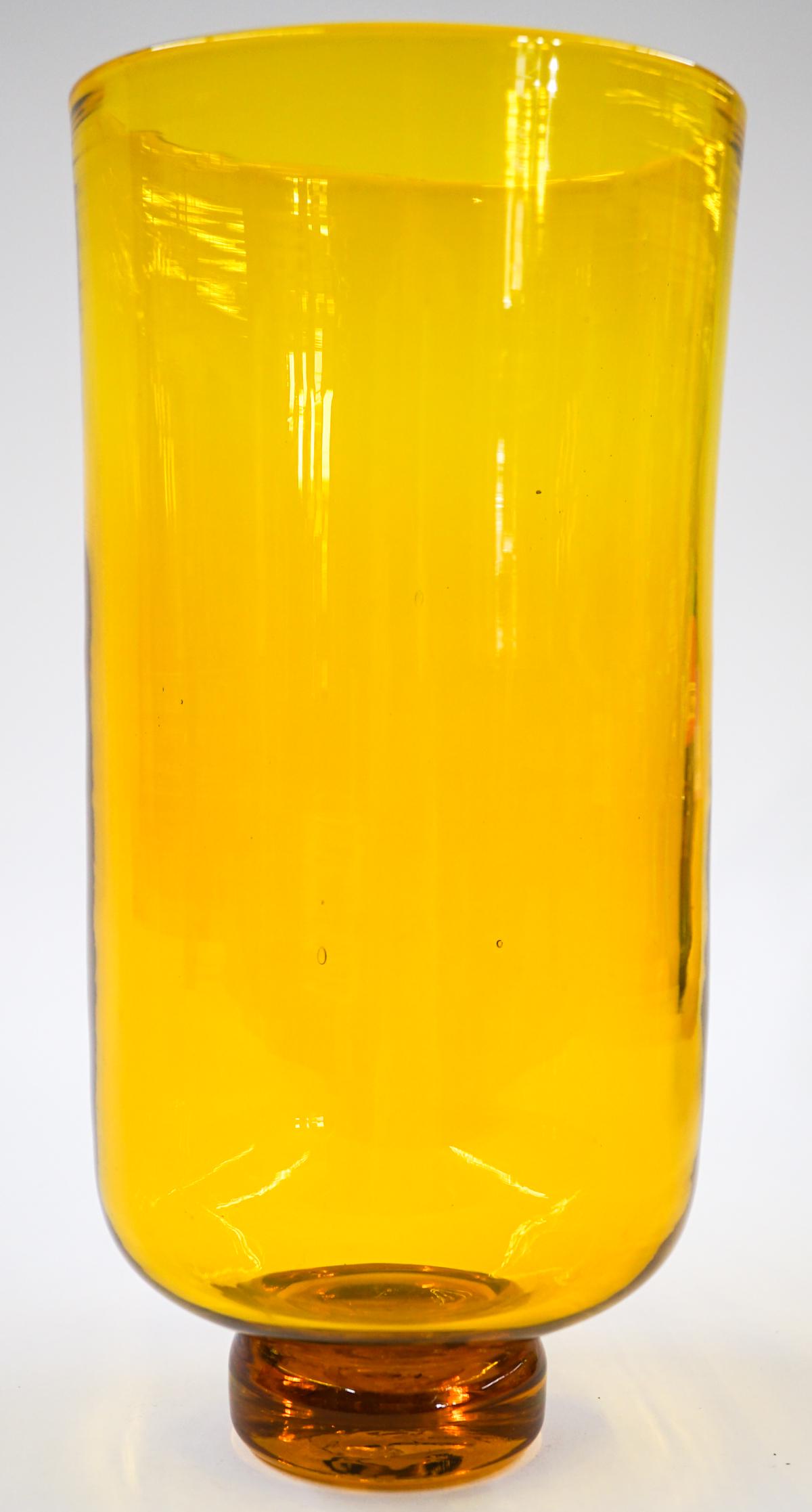 [Blenko] Mid-Century Amber Glass Footed Vase: Blenko (or other maker) mid-century amber glass footed vase. Measures at base 2.5 in. diameter and 5.5 in. across rim with a total height of 11in. No chips, cracks or repairs. Provenance: Tri-Cities, 