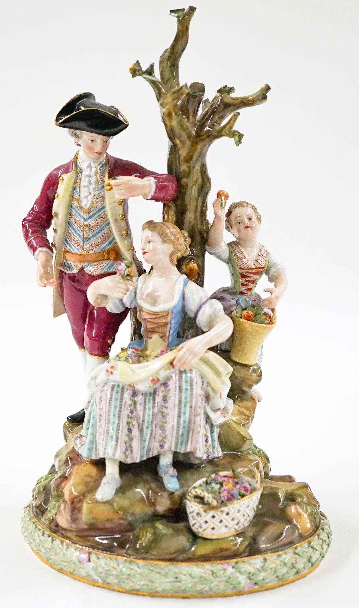 Meissen Figure Group: An antique Meissen large figure group. Measures 10-in. x 5.5-in. x 5-in. Tree branches have been broken and colored at ends. The leaf girl is holding has a chip. Estate sale, being sold as-is. If lot