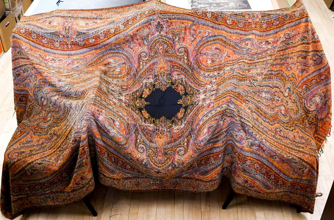 An Antique Paisley Coverlet in Very Good Condition: An antique paisley coverlet. Measures 112-in. x 56-in. Very good condition. If lot is absent of a condition report one may be requested via email. Condition report is provided as an opinion only and i