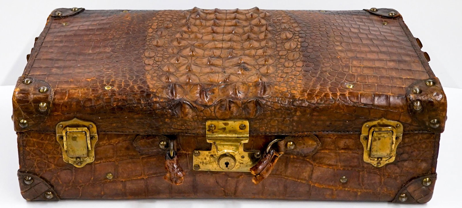 Vintage Crocodile Luggage Suitcase: Vintage crocodile luggage suitcase with brass closures and brads. Carry handle broken off. Leather interior straps with soft leather top garment separator. No markings found. No Key. Measures 23.5 in.