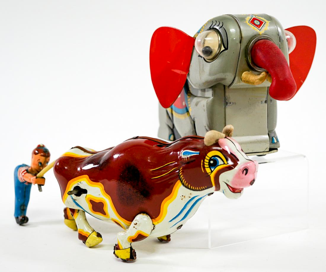 Vintage Tin Toys (2) Elephant and Cow: Two vintage tin toys. Elephant is battery operated, not tested and missing wheel. Measures 6 in. x 7 in. x 5 in. tall. Boy Pulling Cow 's Tail is wind-up and tested, does not come with key. Measures 9