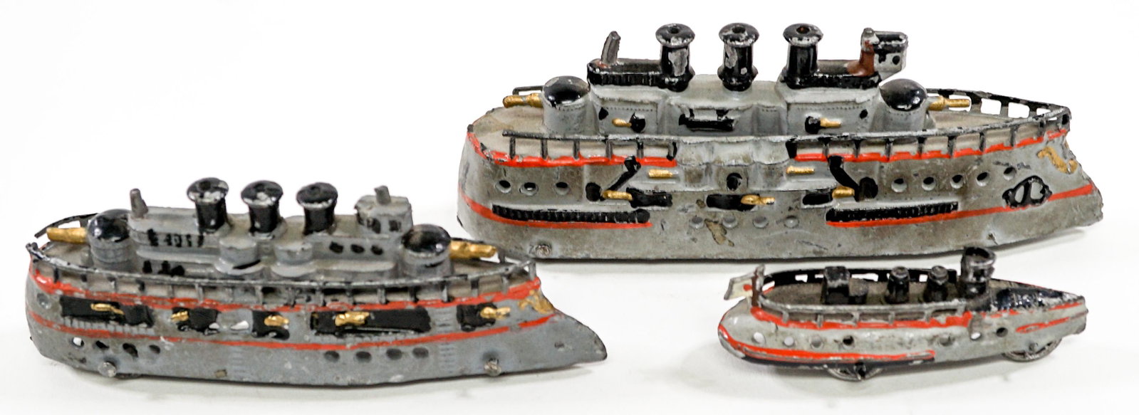 Lead Toy Battleships (3): Collection of three lead toy battleships on wheels. Measure from 2.5 in. to 4.75 in. If lot is absent of a condition report one may be requested via email. Condition report is provided as an opinion o