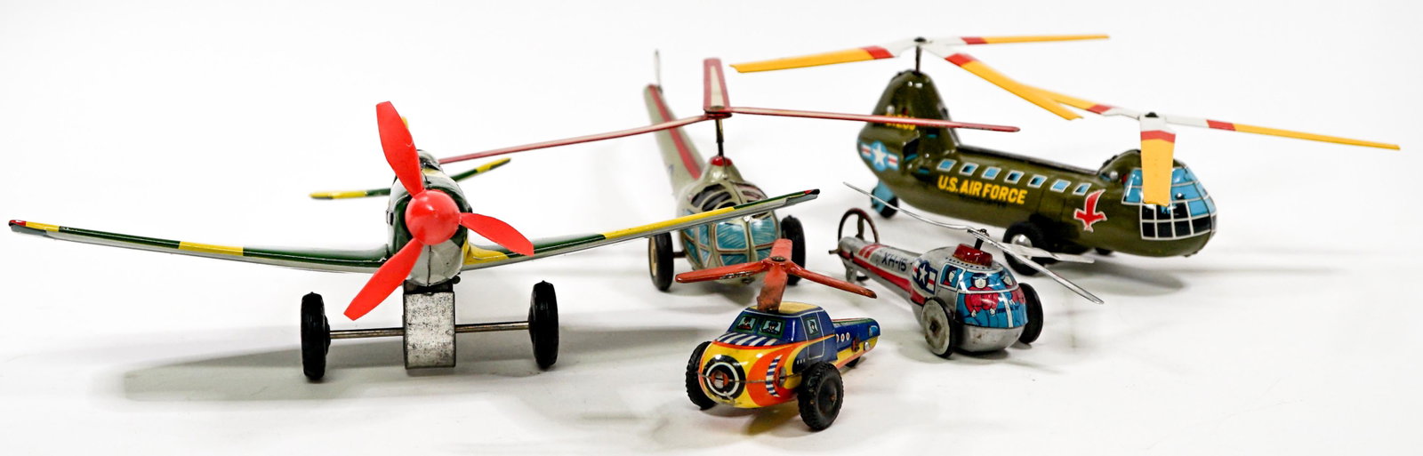 Vintage Metal Toy Helicopters (4) and (1) Plane: Collection of four toy metal helicopters and one plane. Measure from 4 in. to 8 in. long and the plane measures 9 in. If lot is absent of a condition report one may be requested via email. Condition r