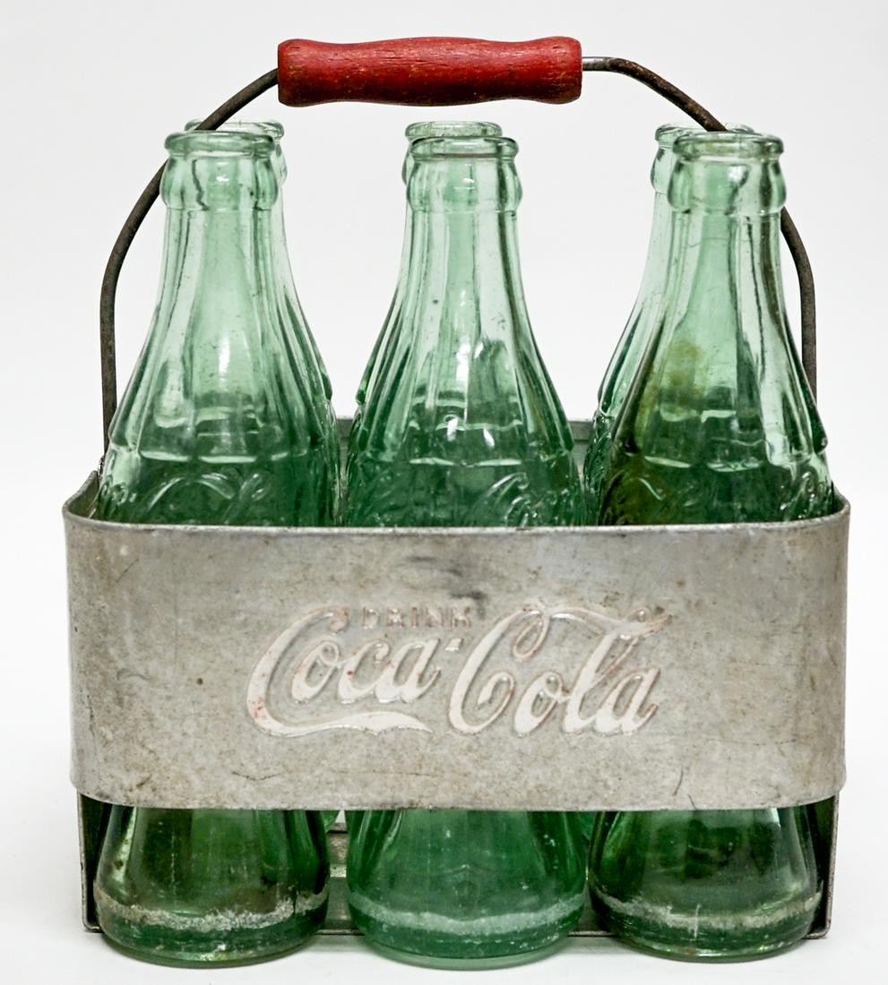 Coca-Cola Vintage Bottles and Carriers: Coca-Cola vintage bottles and carriers. They weigh approximately 15 lbs. combined. If lot is absent of a condition report one may be requested via email. Condition report is provided as an opinion onl