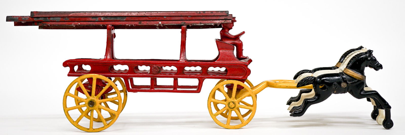 Horse Drawn Hook and Ladder Wagon Toy: Horse drawn hook and ladder wagon toy with rider and three horses. Measures 11.125 in. long x 3 in. wide and 4.25 in. tall. Provenance: From the estate of Clint Max Miller of Seattle and most recently
