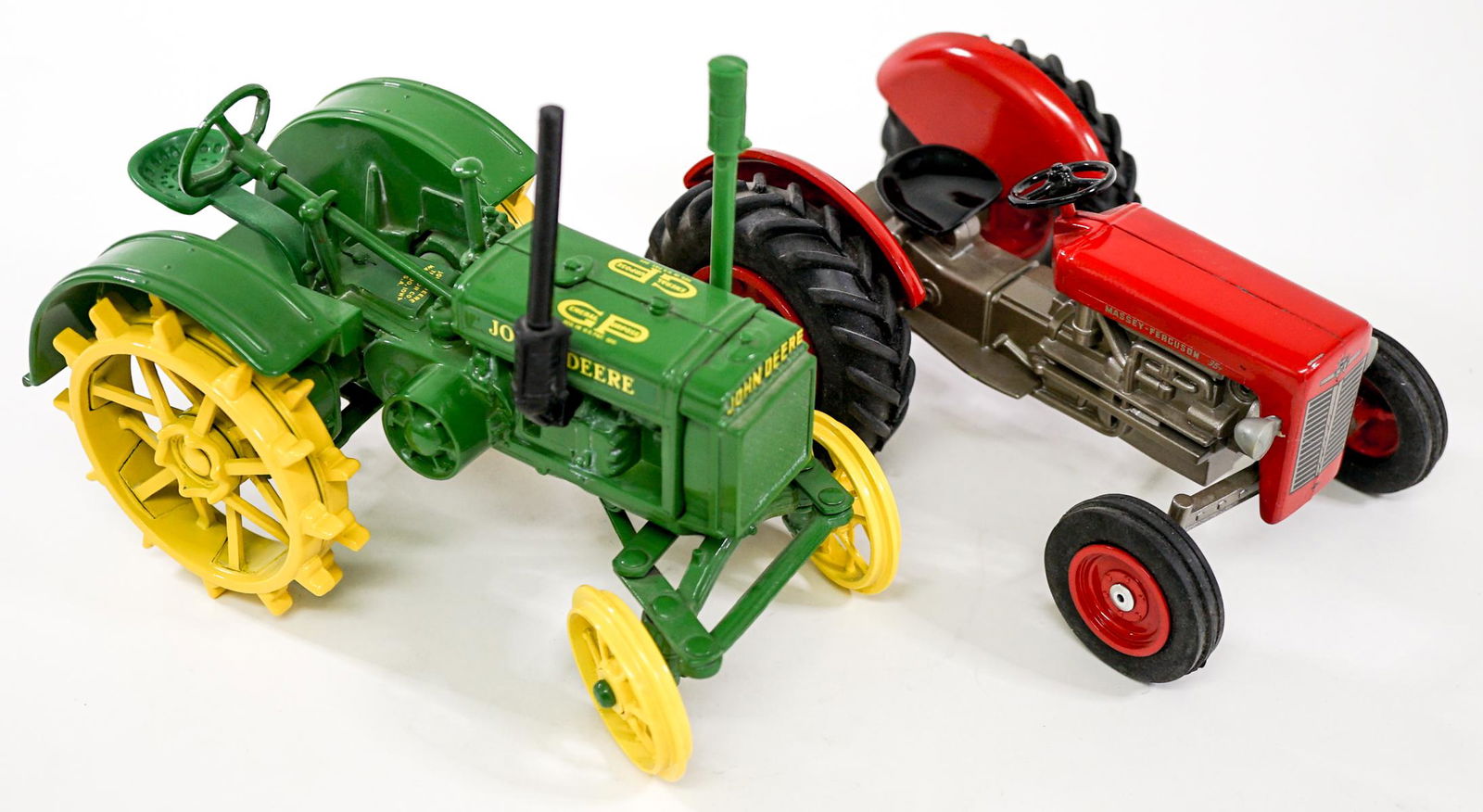 Metal Toy (2) Tractors: Two (2) push toy diecast metal tractors. Includes: John Deere measures 7 in. x 4 in. x 5.5 in. tall; and Massey Ferguson 35 with rubber tires measures 6.75in. x 4.125 in. x 3 in. tall. Provenance: Wil