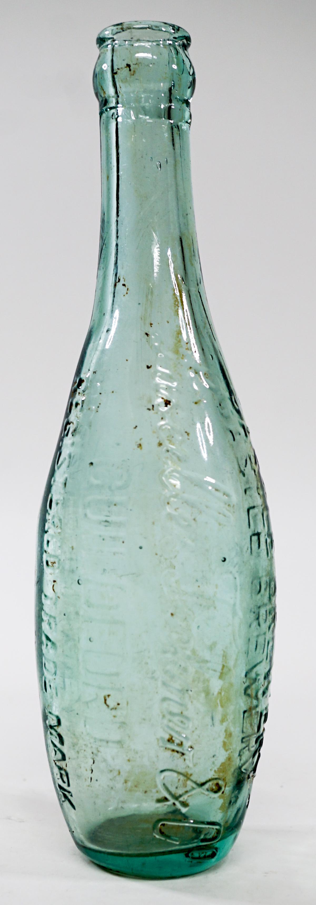 Vintage Castle Brewery Guildford Bottle: Vintage Castle Brewery Guildford light green glass bottle. Measures 9 in. tall and 1.5 in. across base. If lot is absent of a condition report one may be requested via email. Condition report is provi