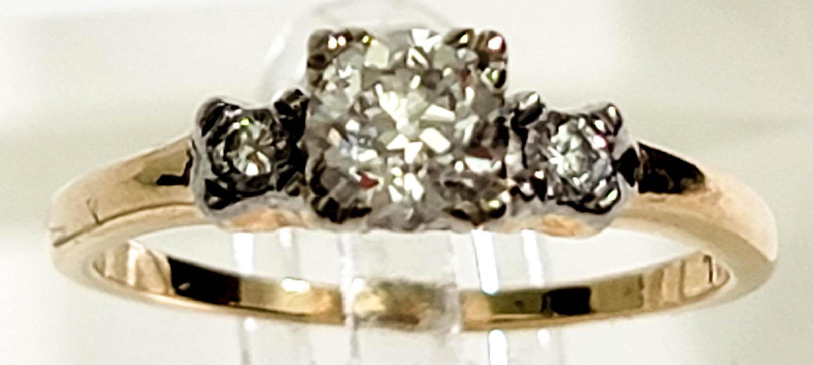 14k Gold & 18k Diamond Ring 0.61 ctw SI1: The ring is centered with a round old European cut diamond in a four-prong white gold setting atop a yellow gold shank. The center is flanked on each side by one (1) four-prong set, round brilliant cu