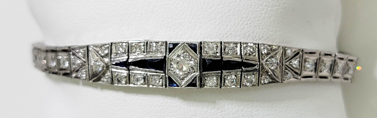 Art Deco Platinum Diamond Bracelet 2.65 ctw: The Art Deco bracelet features milgrain details and is centered with a round old European cut diamond in a hexagonal bead setting. The center is accented with a total of ten (10) bezel set, calibre cu