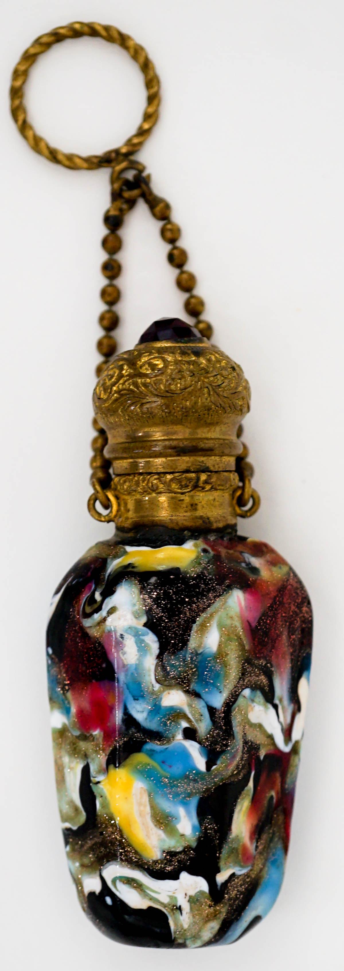 Vasa Murrhina Antique Scent Bottle: Gold hinges, lid and collar. Multi-colored glass with gold mica flecks. Has chain with finger ring. Hinged-top, no stopper. Measures 2.8125 inches x 1.25 inches. No damage. Provenance: Previously Sabr