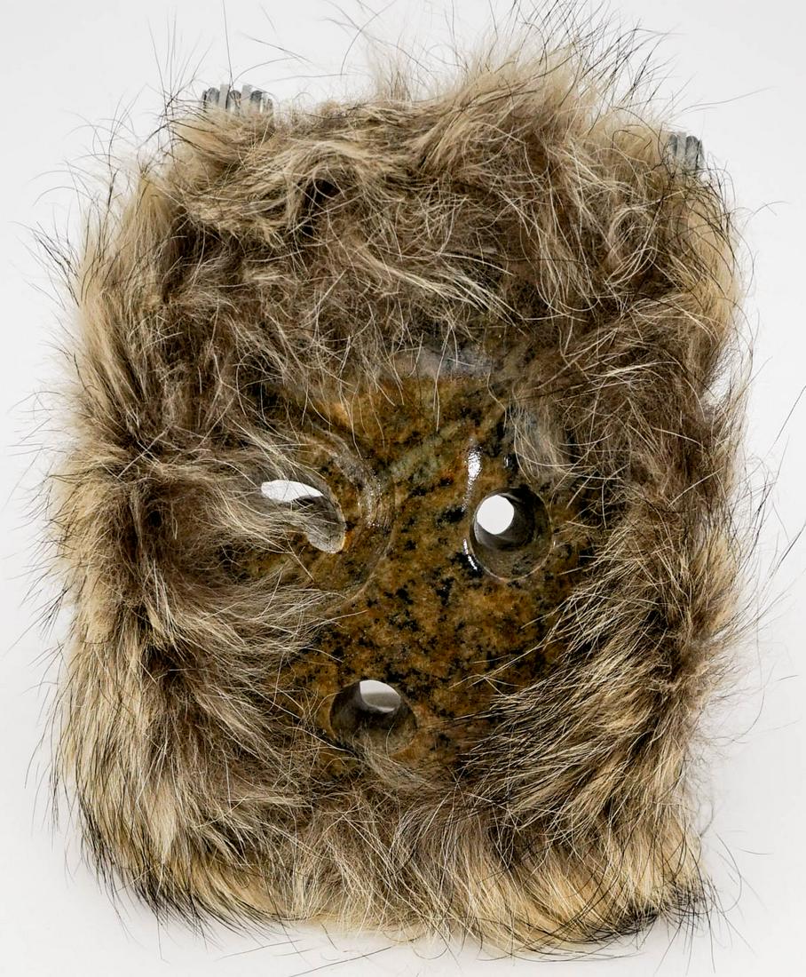 Eddie Scott Stone Carved Mask: Northwest Coast stone carved mask signed 'Eddie Scott' top edge on verso. Mask measures 3.25 in. x 4 in. with 1 inch fur surround. If lot is absent of a condition report one may be requested via email