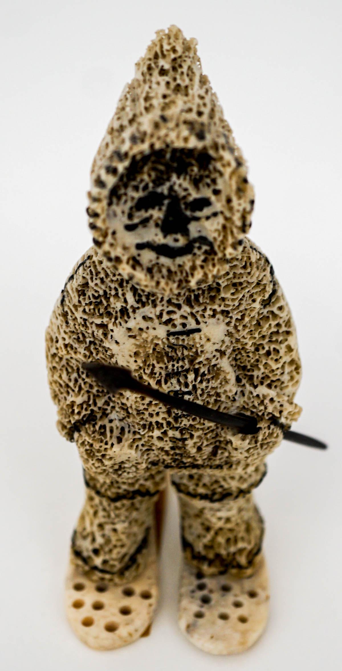 Pacific Northcoast Carving Eskimo: Pacific Northcoast carving of a man with a spear in snowshoes. Fossilized bone. Measures 3.75 in. tall and 1.75 in. x 2.25 in. wide. If lot is absent of a condition report one may be requested via ema