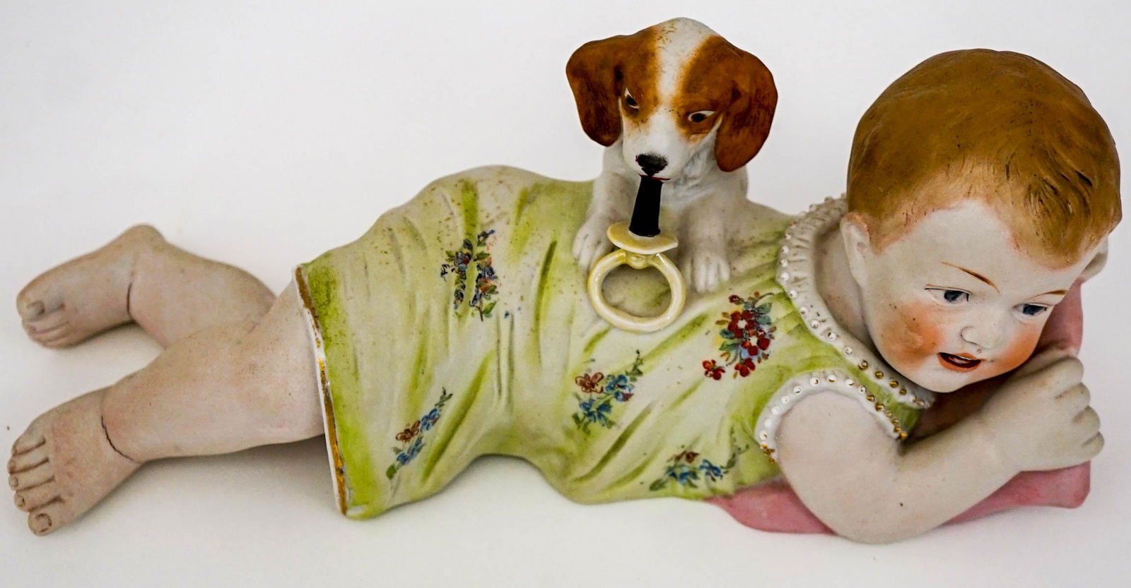 Piano Baby: An old bisque piano baby. Measures 4-in. x 9.5-in. x 3.75-in. No cracks, chips or repairs. Firing flaws or factory flaws at ankles. Provenance: Mary Carter collection, Spokane, Wa. This item requires