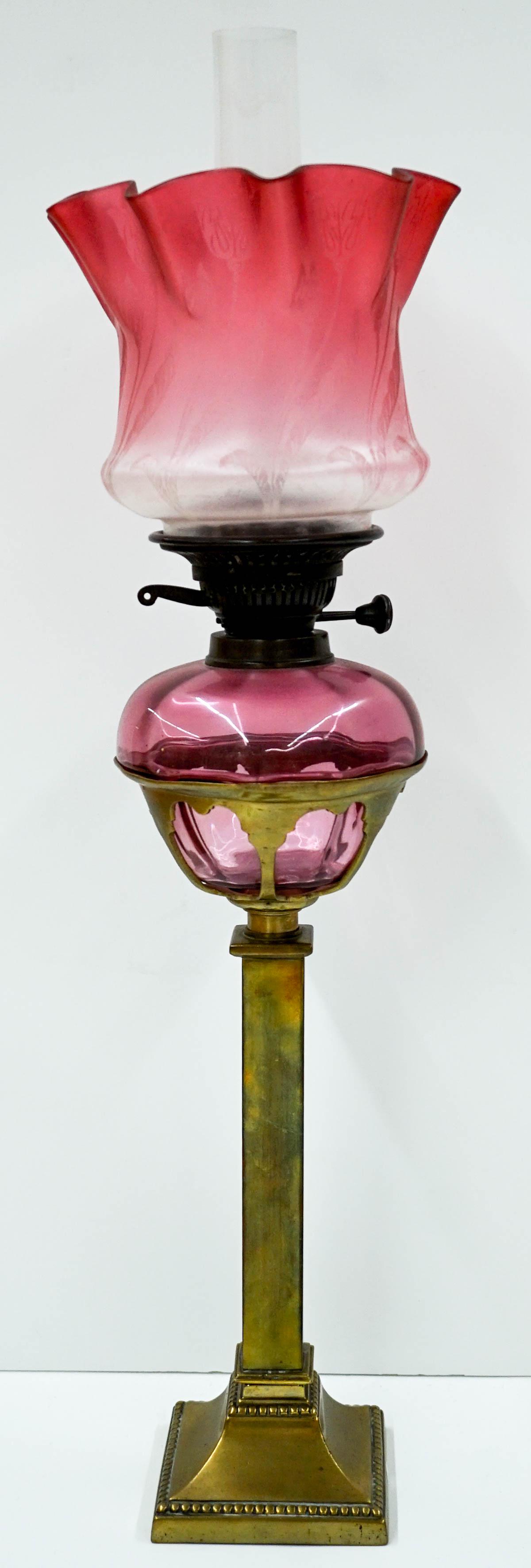 Vintage Hurricane Oil Lamp [Brass]: Vintage hurricane oil lamp with slim brass stand and rose colored tulip shade. Stands 28 in. tall with chimney x 8 in. across shade x 4.75 in. across weighted base. Weighs 10 lbs. Untested. If lot is 