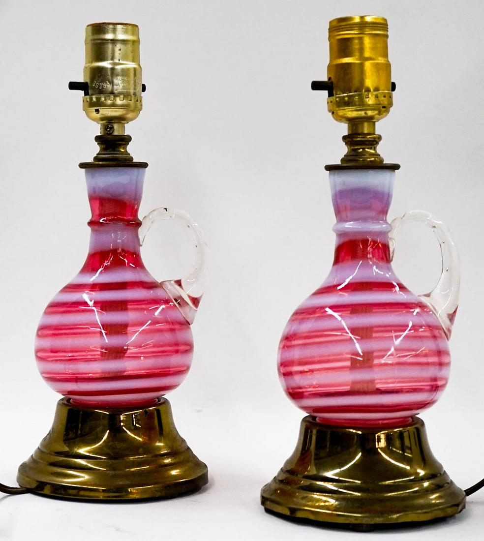 Pair Cranberry Opalescent Swirl Dresser Lamps: Pair Cranberry Opalescent Swirl Dresser Lamps. They measure 10.5 inches tall. No Damage. If lot is absent of a condition report one may be requested via email. Condition report is provided as an opini