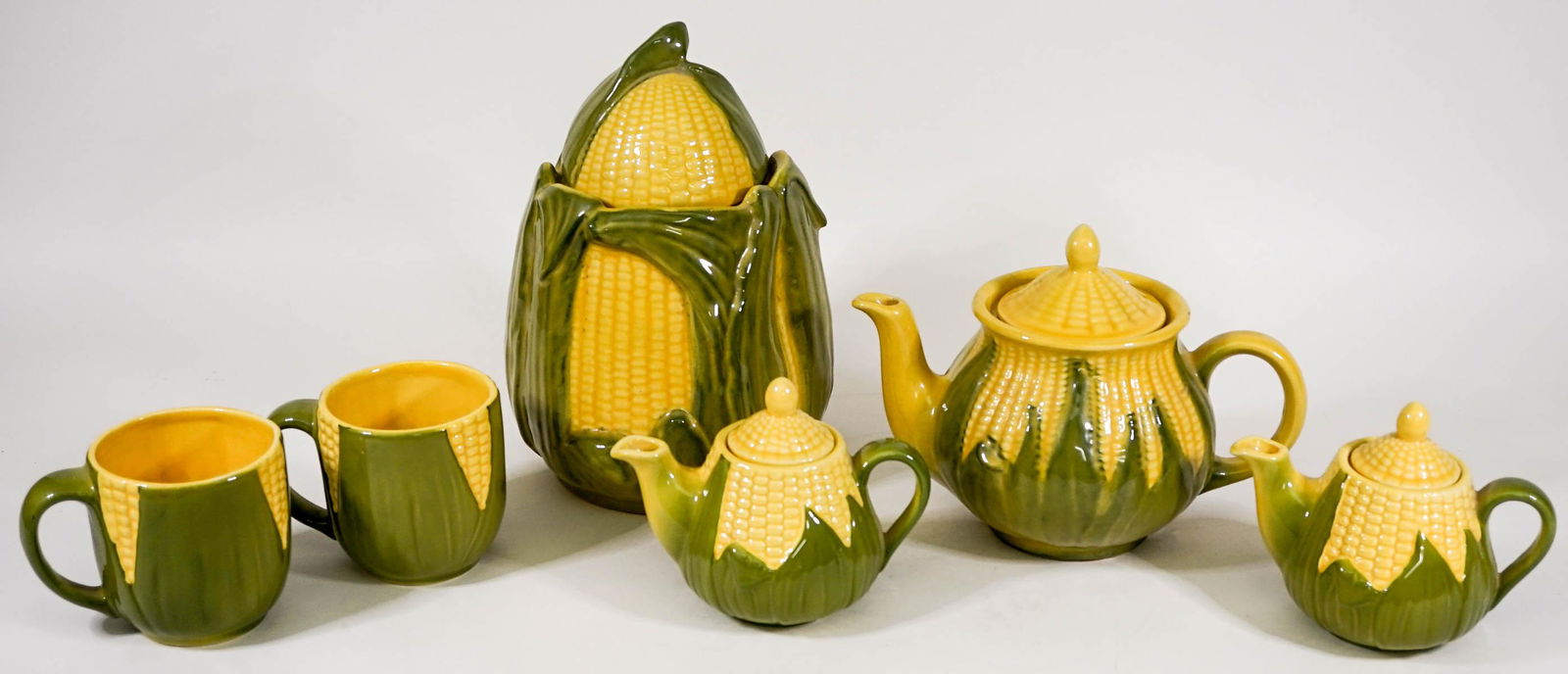 Shawnee (10 PC) Pottery King Corn Serveware: Ten (10) pc vintage Shawnee pottery King Corn serveware. Includes: Lidded 7 in. teapot , (2) single serve 4.5 in. lidded teapots, covered 10 in. cookie / biscuit jar and (2) 3.5 in. mugs. No evidence