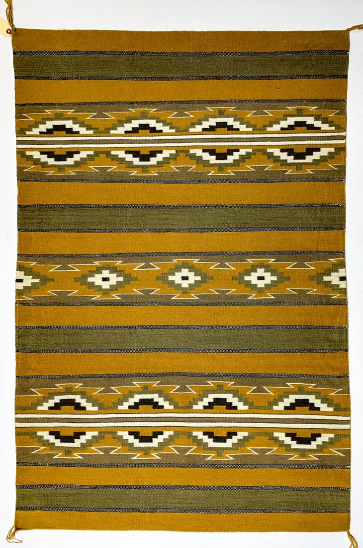 Navajo Wide Ruins Weaving 51.5 x 34.5: Navajo Wide Ruins weaving (Etta Mae Lewis, weaver, appraised May 13, 1970 by Packard's Chaparral Trading Co., Santa Fe, New Mexico), measures 51.5 in. x 34.5 in. and is in colors of browns, green, gol
