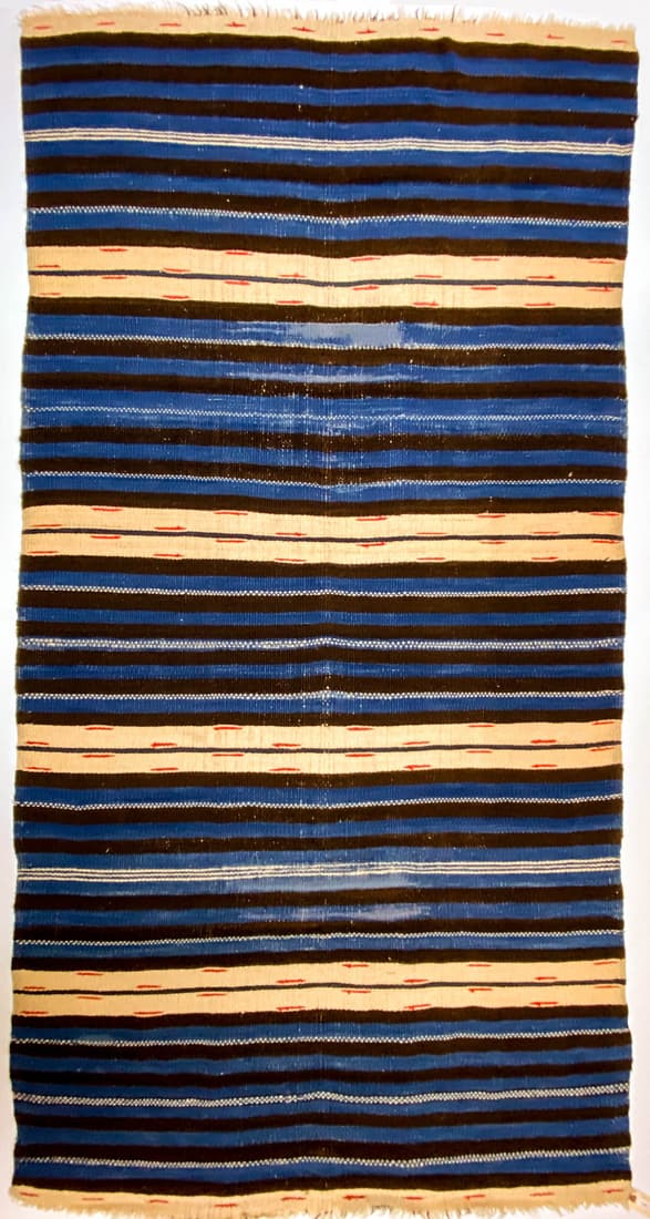 Rio Grande Rug Ca.1875. 48.5 x 93.5 Inches: Rio Grande Rug (weaver unknown), approximately circa 1875, measures 48.5 in. x 93.5 in. with Indigo blue, brown, and white natural sheep colors, red (berry dye). Has repairs/damage (as seen in lighter