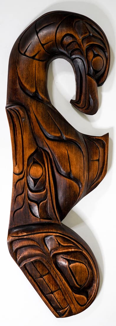 Alfred Robertson Northwest Coast Figural Carving: Alfred Robertson (Kwakwaka'wakw First Nations, b. 1950) Eagle, Raven, Whale cedar carved plaque measures 16 in. x 5 in. x 1.5 in. deep. No evidence of damage or repair. Provenance: Private Collection.