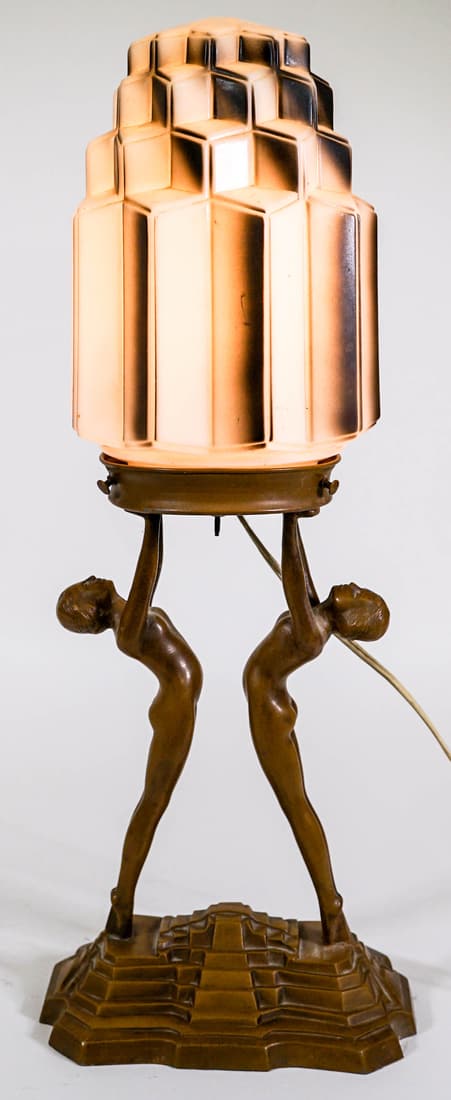 Art Nouveau Pot Metal Lamp [2 Women; Building]: Unusual Art Nouveau electric lamp. The Base is painted pot metal and features 2 women reaching upward and the black and white glass shade is cubic shapes. Tested and works. Measures 19 in. tall x 8 in
