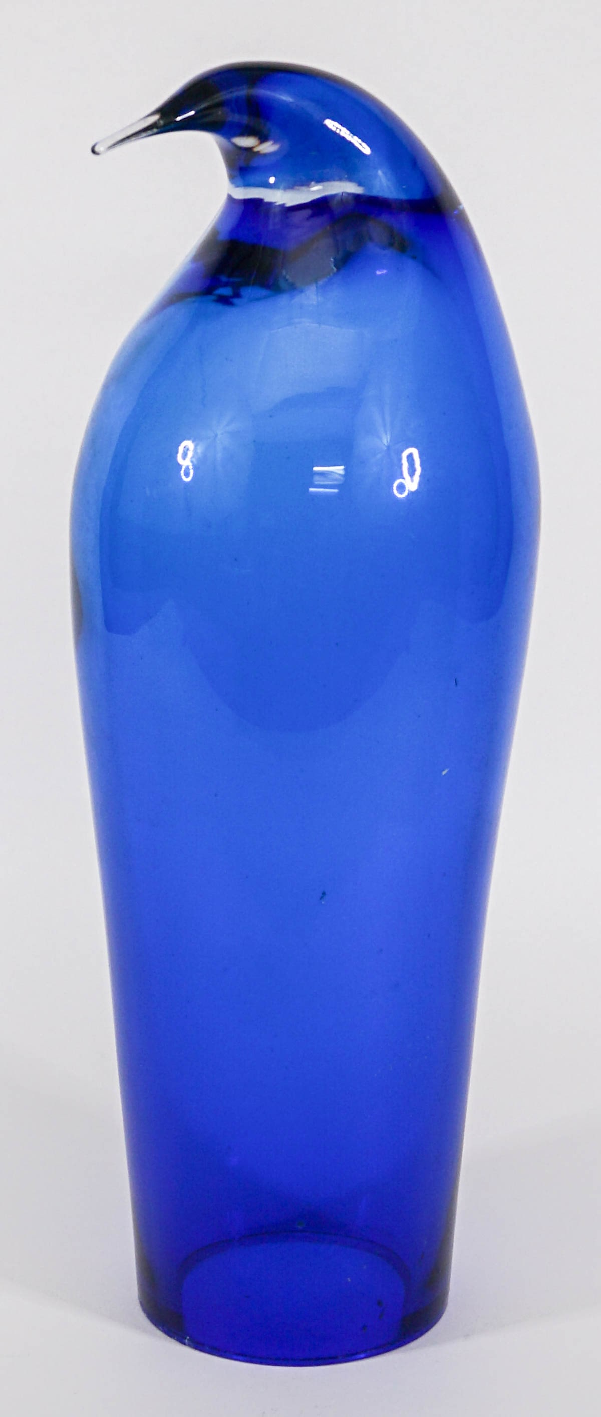 Blenko Glass 15 IN Penguin [Sapphire]: Blenko glass penguin measures approximately 15 in. tall x 5 in. wide. Small chips around base. If lot is absent of a condition report one may be requested via email. Condition report is provided as an