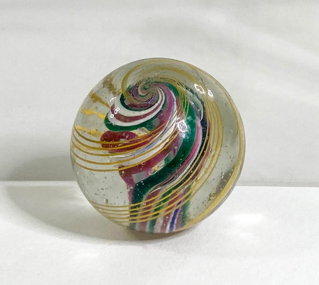 Vintage (1) Swirl Core Marble 1.125 IN Diameter: Vintage swirl marble measures approximately 1.125 in. diameter. Tiny chip to one end. Provenance: Montana private collection. If lot is absent of a condition report one may be requested via email. Con