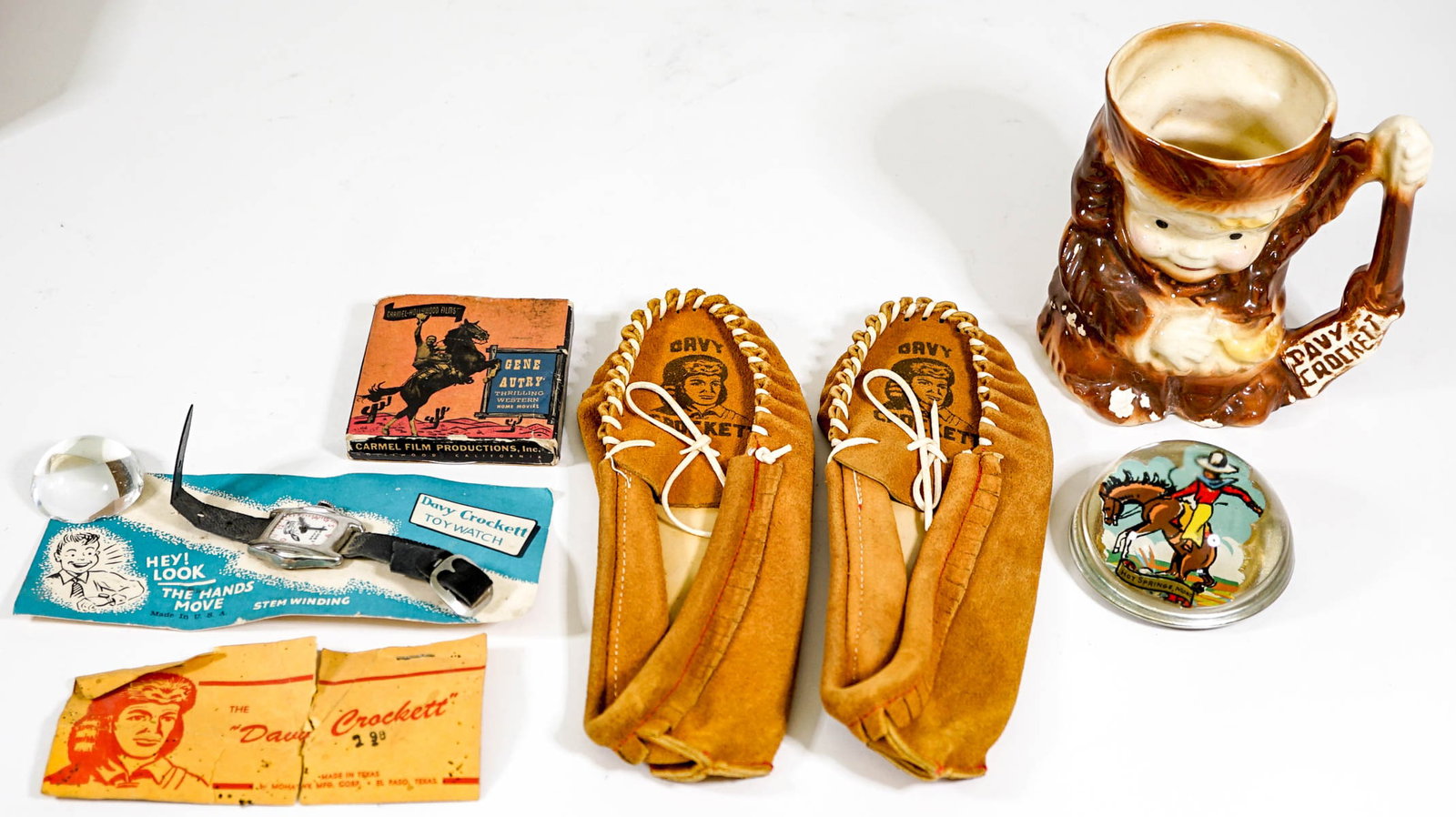 Davy Crockett Collectibles and more: Includes a watch (unworn, strap as-is) a pair of moccasins (Like-new, unworn), and mug as-is. If lot is absent of a condition report one may be requested via email. Condition report is provided as an 
