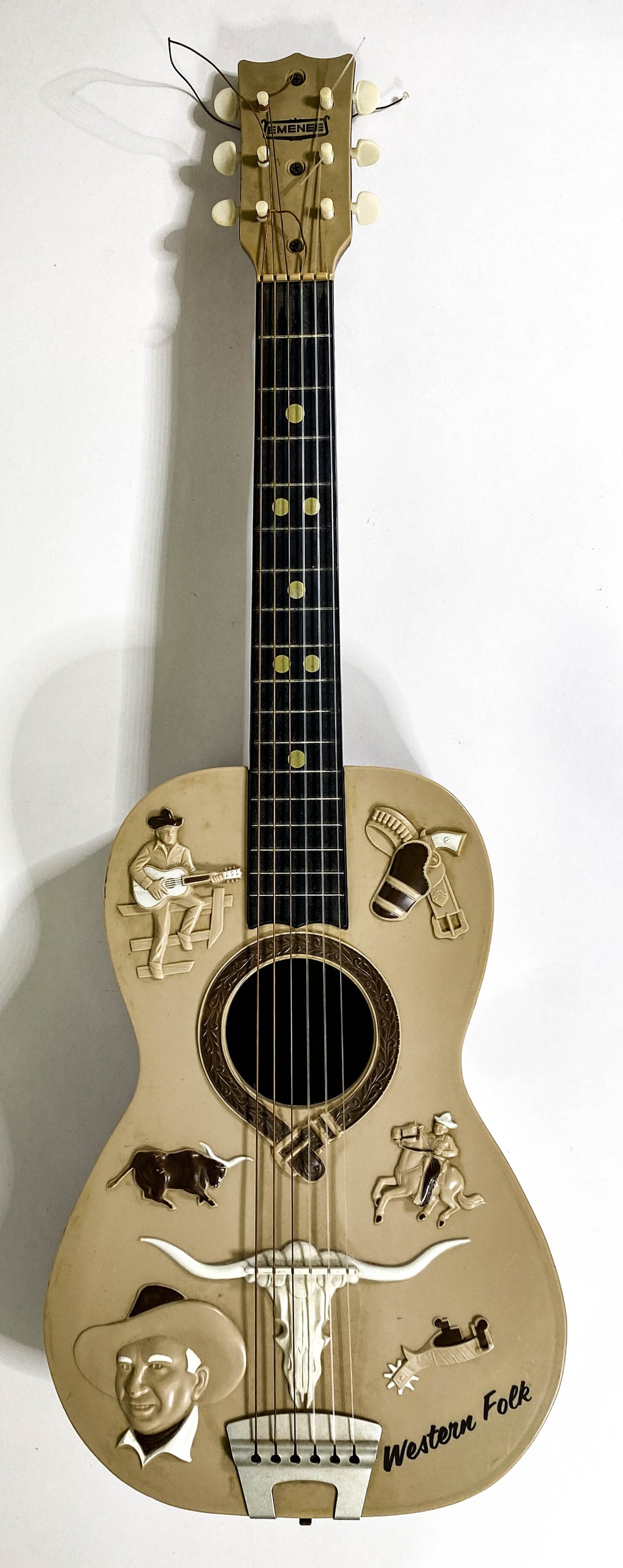 Vintage Emenee Gene Autry Western Folk Toy Guitar: Vintage Emenee Gene Autry Western Folk Toy Guitar. Measures 31.5 inches length. Needs a tuning and further cleaning. If lot is absent of a condition report one may be requested via email. Condition re