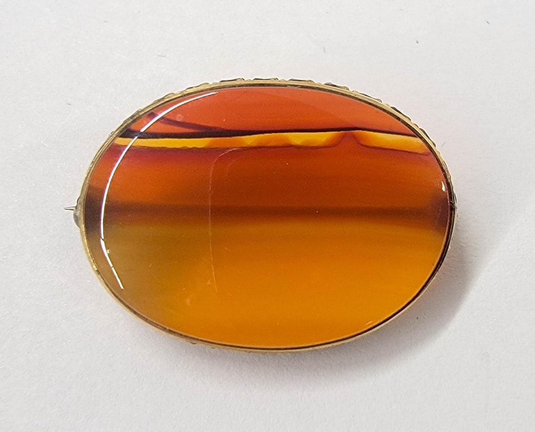 An Antique Agate Oval Pin: An Antique Agate Oval Pin in Gold Filled Setting. Measures 23 16 mm. No damage. If lot is absent of a condition report one may be requested via email. Condition report is provided as an opinion only a
