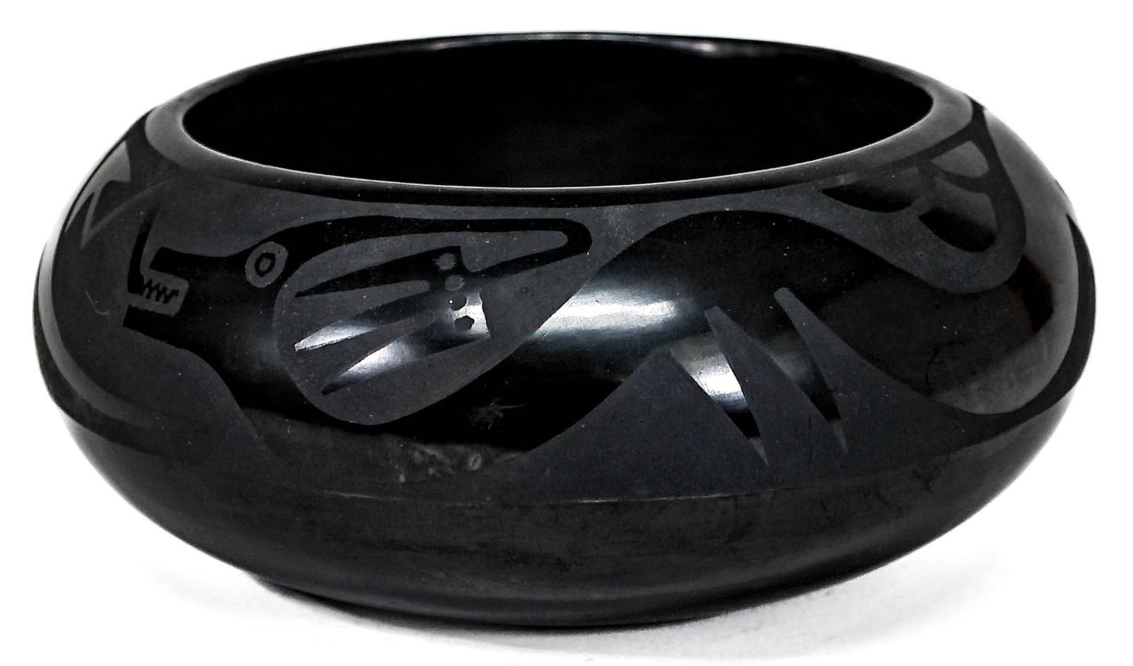 San Ildefonso, Santana + Adam Martinez, Blackware: Bowl with Avanyu Motif, or Water Serpent . Purchased in the 1960's by consignors parents. Measures 3.625 inches x 8 inches. No cracks, chips or repairs. Excellent condition with a small scuff to the f